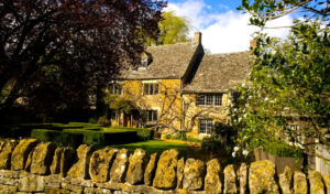 Cotswolds cottages behind an old stone wall