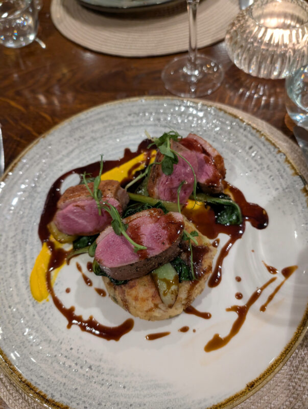 A delicious plate of food showing beef vegetables and sauces poured artistically around the plate