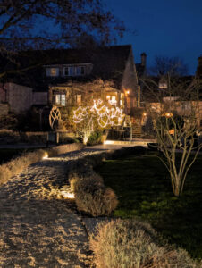 View of inn at night with lights twinkling in trees