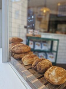 Loaves of bread lined up in the window of a cafe