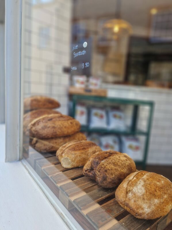 Loaves of bread lined up in the window of a cafe