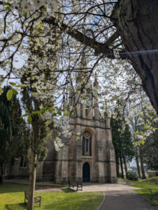 Path leading to a church with pink blossoms overhead