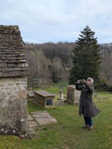 Female hiker taking a photo of an ancient Saxon church