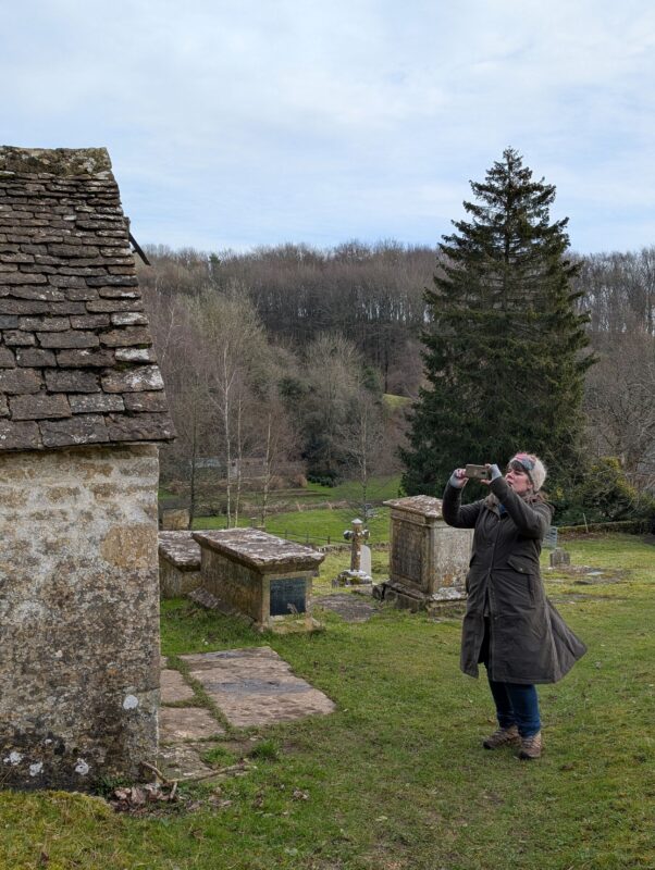 Female hiker taking a photo of an ancient Saxon church