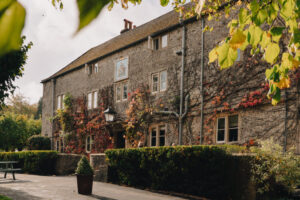 Exterior of a cosy country inn with autumn foliage in the foreground