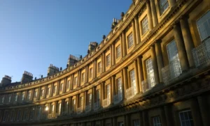 A curve of grand Georgian town houses with large windows catching the evening sun.