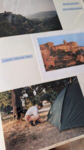 Image of printed photos in an album showing landscapes of France and a young David Howell putting up a tent