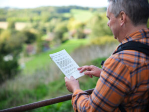 A hiker stops at a gate to read instructions on his self-guided walking trail guide
