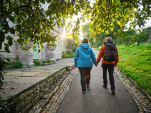 Two people hike along a scenic path in The Cotswolds, England