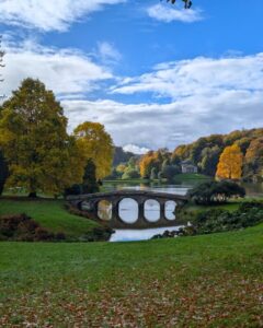An ornate bridge set in a grand country estate and surrounded by autumnal trees