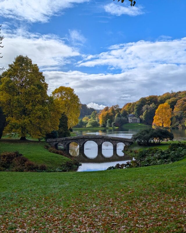 An ornate bridge set in a grand country estate and surrounded by autumnal trees