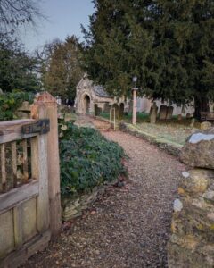 Photo of a gate and gravel path leading to an old church.