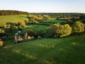 Aerial shot of two people walking and hiking in England's countryside