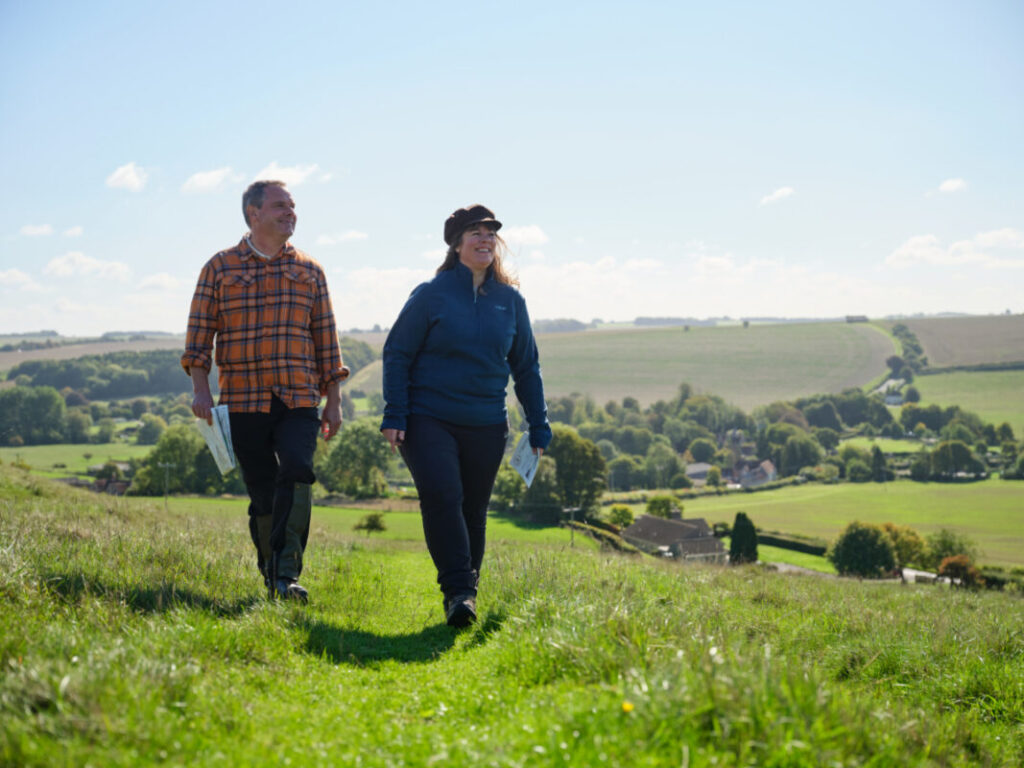 An image of two people hiking on the beautiful scenic hills of England.