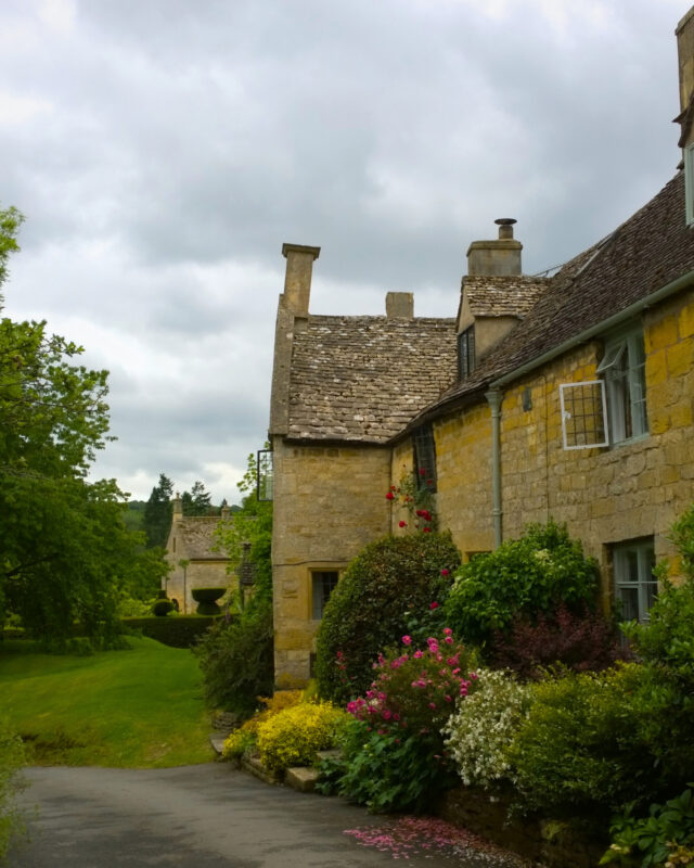 View of classic Cotswolds cottages next to a quiet country lane