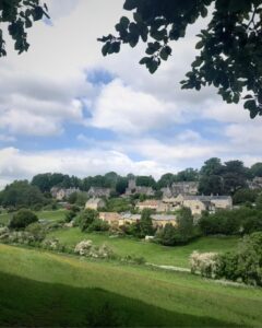 View of a village with old stone buildings nestled in a green valley.