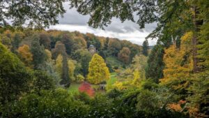 View of the Stourhead estate in autumn with the temple of apollo in the distance.