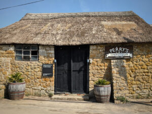 View of an old cider barn with a thatched roof.