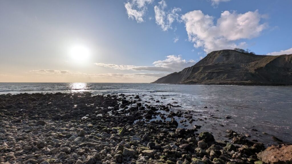 View of a secluded cove with a cliff towering in the distance
