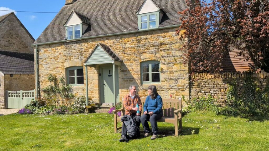 Foot Trails Founders David and Alison sat on a bench chatting and drinking from a water bottle
