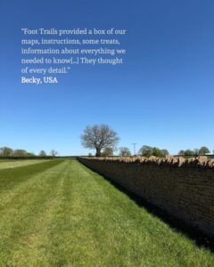 A field stretching off into the distance with a drystone wall to the left. A quote from a guest is superimposed in the top left corner.