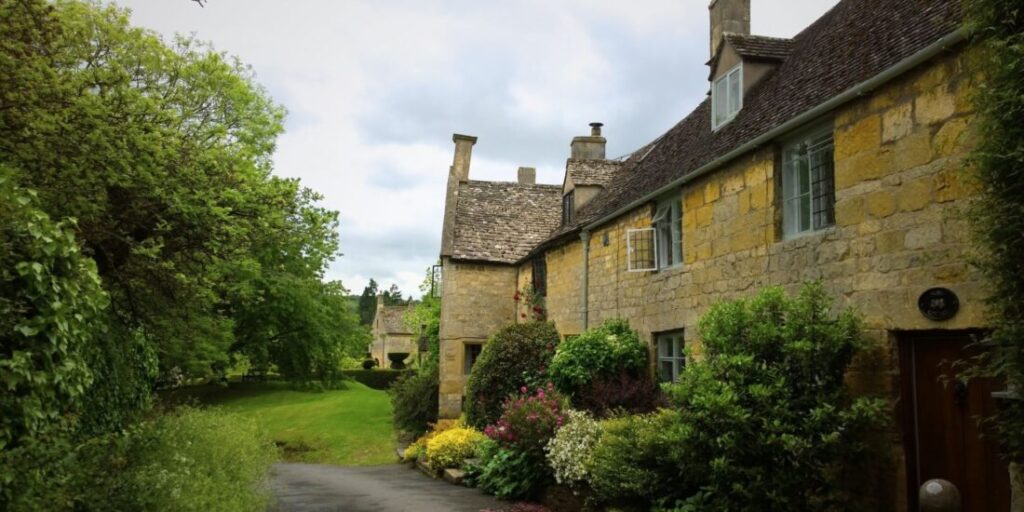 A row of cottages in the Cotswolds made of golden yellow stone and with stone slate roofs