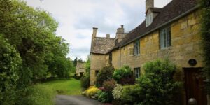 A row of cottages in the Cotswolds made of golden yellow stone and with stone slate roofs