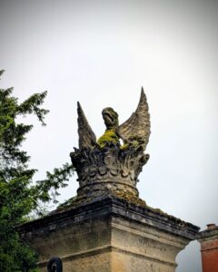 A stone griffin on top of a stone gatepost