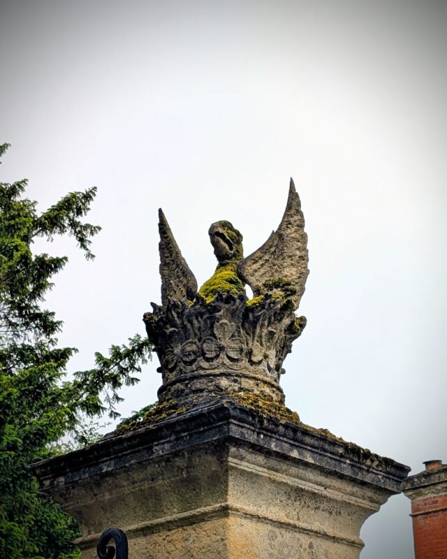 A stone griffin on top of a stone gatepost