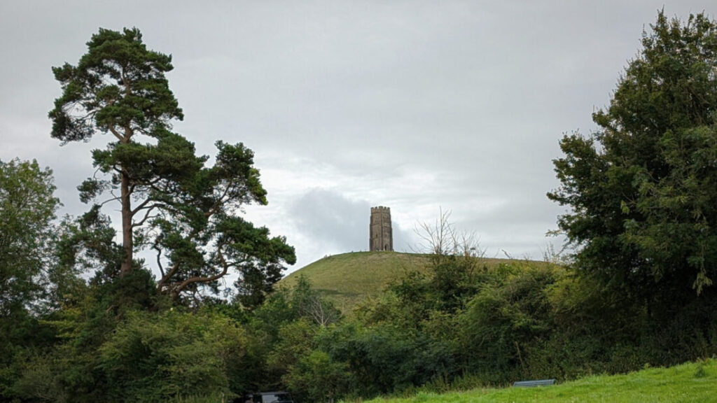 View of Glastonbury Tor from a distance through a gap in the treees