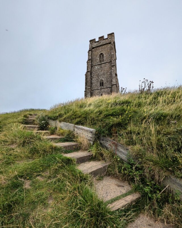 View of Glastonbury Tor from the steps leading up to the church tower.