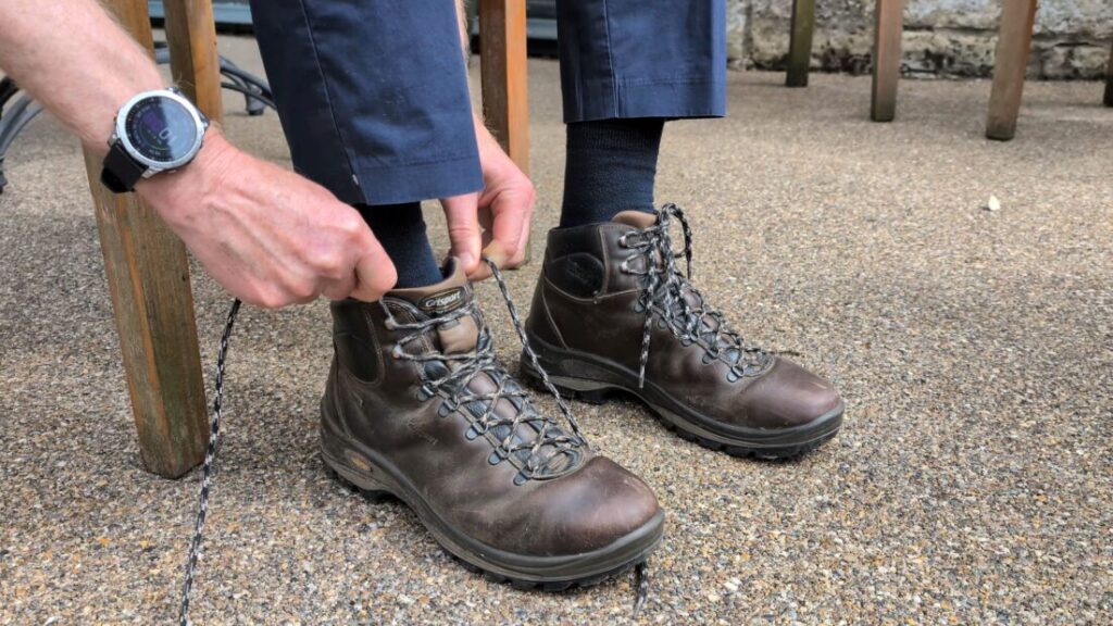 Close up of a pair of hands lacing up a hiking boot