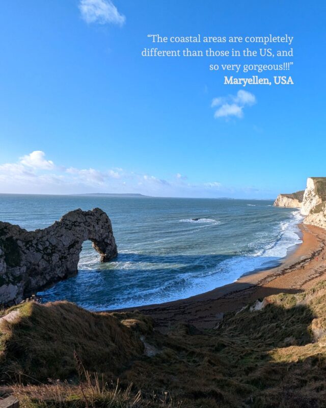 Image of Durdle Door on the Dorset coast from the cliffs. A guest quote is superimposed over the bright blue sky: “The coastal areas are completely different than those in the US, and so very gorgeous!!!” Maryellen, USA