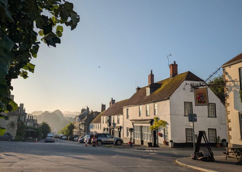 View of a main road through a country village on an autumn morning with a cosy country inn to the right.